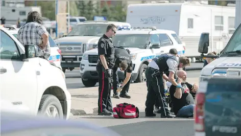  ?? TROY FLEECE ?? Police, fire and EMS converged on Prince of Wales Drive north of Victoria Avenue on Monday to help a man, shown seated on the roadway, after it is believed he was hit by a motorhome which left the scene. The driver of the motorhome was arrested a short...