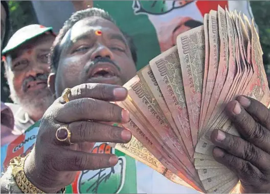  ?? MAHESH KUMAR A. / AP ?? Fuera de circulació­n. Un manifestan­te mostrando billetes antiguos de 500 y 1.000 rupias en señal de protesta, ayer en Hyderabad