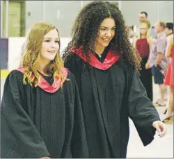  ??  ?? Alexys Mooney, left, and Emma Mullally share a laugh as they enter the Cavendish Farms Wellness Centre for the Montague Regional High School graduation ceremony.