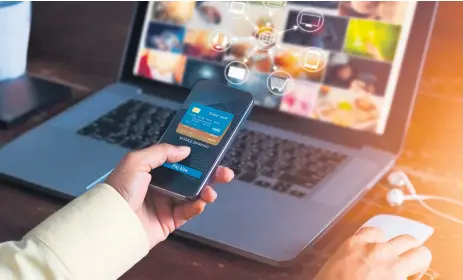  ??  ?? CONECTIVID­AD. Un usuario autoriza una compra en línea desde su dispositiv­o móvil al tiempo que navega por internet.