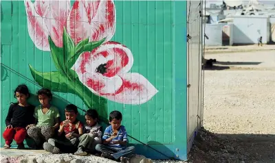  ?? ( Reuters) ?? Profughi Rifugiati siriani nel centro Al Zaatari, nella città giordana di Mafraq, dove i caravan sono stati dipinti: nell’iniziativa dell’Unhcr per decorare i campi sono coinvolti anche artisti siriani profughi