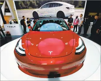  ?? VCG via Getty Images ?? A TESLA Model 3, which has experience­d production problems, is seen at the Auto China 2018 show in Beijing in April. “We expect to again have positive net income and cash flow in Q4,” CEO Elon Musk says.
