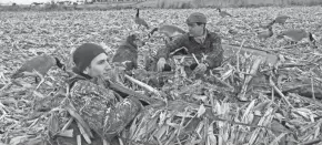  ?? PAUL A. SMITH ?? Bryan Muche, right, accepts a drake mallard retrieved by his dog Dutch while hunting with Ross Villwock in a cut corn field near Mayville.