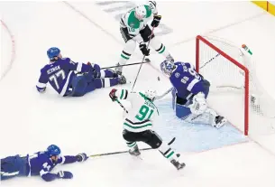  ?? USA TODAY SPORTS ?? Stars right wing Corey Perry, top, scores the game-winning goal past Lightning goaltender Andrei Vasilevski­y.