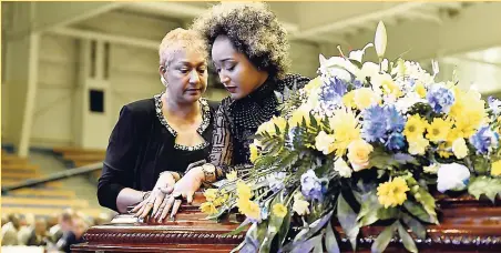  ?? GLADSTONE TAYLOR ?? Ian Boyne’s daughter, Kelly-Ann Boyne (right), and her mother, Sharon Woodland (left), are overcome with grief during the funeral of the veteran journalist at the National Indoor Sports Centre in St Andrew yesterday.