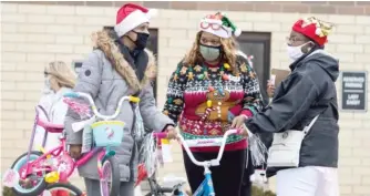  ??  ?? Volunteers distribute bikes Saturday outside People’s Church of Harvest in the Fifth City neighborho­od.