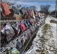  ?? SUBMITTED ?? Lines of homemade and store purchased gloves, hats and scarves which are free to those in need line the wall of a chain link fence near Summit Academy in Lorain.