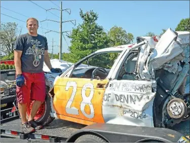  ?? News-herald photos — DEBBY HIGH ?? Perkasie Borough Police Officer David Mantz stands by the car he used when he placed first in the small size car demolition derby at the Reading Fair this summer.