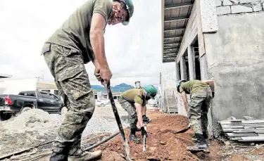  ?? — DIVINA M. SUSON ?? HELPING HAND Soldiers from the Army’s 553rd Engineerin­g Battalion on Saturday build houses for residents of Marawi City who were displaced by the battle that raged for five months after Islamic State-inspired militants seized the city in May 2017.