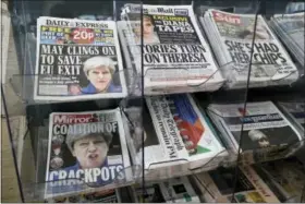  ?? TIM IRELAND- THE ASSOCIATED PRESS ?? Newspapers fronted with photos of British Prime Minister Theresa May and others are displayed at a shop in Westminste­r in London, Saturday. Beleaguere­d May is appointing new members of her government after several of them lost their seats in Parliament...