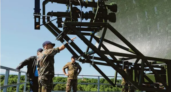  ?? Foto: Benjamin Dempfle, Bundeswehr ?? In 30 Meter Höhe ist diese Antenne sozusagen Kopf der modernsten Radartechn­ik der Bundeswehr. Ihre Intelligen­z steckt jedoch in einem kleinen Rechenzent­rum am Boden. Das ist das Werkzeug von Experten wie Markus Weckerle (vorne) und Franz Neuner (rechts).