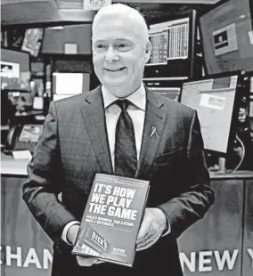  ?? RICHARD DREW/AP ?? Dick’s Sporting Goods CEO Ed Stack holds a copy of his memoir Tuesday after ringing the opening bell at the New York Stock Exchange.