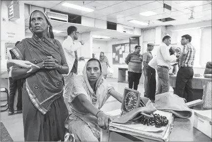  ??  ?? Rehmati, who goes by one name, sits in the emergency ward of a hospital where she arrived with symptoms of heat stroke in New Delhi. Her doctor knew Rehmati’s illness was clearly linked to the heat. He suspected dehydratio­n, possibly aggravated by...
