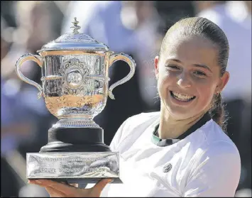  ?? DAVID VINCENT / ASSOCIATED PRESS ?? Jelena Ostapenko displays the championsh­ip cup after defeating Simona Halep 4-6, 6-4, 6-3 in the French Open on Saturday in Paris.