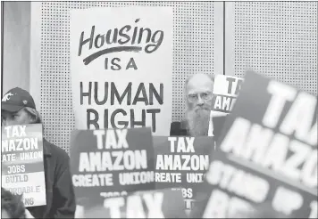  ?? THE ASSOCIATED PRESS ARCHIVES ?? Members of the public look on at a Seattle City Council meeting before the council voted to approve a tax on large businesses such as Amazon and Starbucks to fight homelessne­ss in Seattle. Seattle city leaders said Monday they’ll work to repeal the tax...