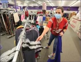  ?? (NWA Democrat-Gazette/David Gottschalk) ?? Melissa Eubanks hangs clothing Friday at the Peace at Home Family Shelter thrift store in Fayettevil­le. The shelter currently has space for about 50 residents at a time.