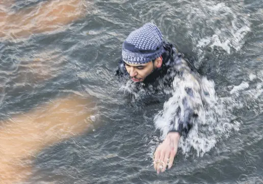  ??  ?? A migrant swims back toward Turkey after attempting to enter Greece by crossing the Maritsa river, March 1, 2020.