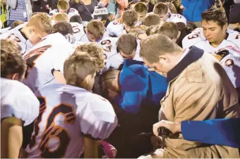  ?? LINDSEY WASSO/THE SEATTLE TIMES 2015 ?? Bremerton High School football coach Joe Kennedy leads his team in prayer following a loss in Bremerton, Wash., near Seattle. The Supreme Court this year ruled in favor of Kennedy’s right to pray on the field.