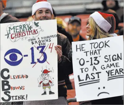 ?? David Richard ?? The Associated Press Disgruntle­d Browns fans hold up signs after the Baltimore Ravens pushed host Cleveland to 0-14 with a 27-10 defeat on Sunday.
