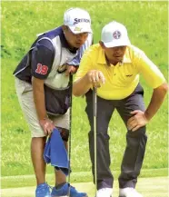  ?? Manny Marcelo ?? Loenard Rates consults with his caddy.