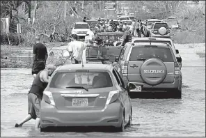  ?? AP/CARLOS GIUSTI ?? Vehicles travel a flooded road Friday after Hurricane Maria passed through Toa Baja, Puerto Rico, where thousands of people were evacuated when the gates of the Rio La Plata Dam were opened.