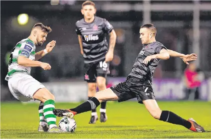  ??  ?? Dundalk’s Michael Duffy stretches to get the ball ahead of Greg Bolger of Shamrock Rovers