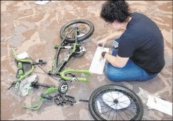  ?? GLVAR ?? GLVAR member Diana Jenkins assembles a bike to be donated to the toy drive.