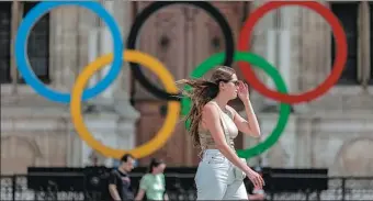  ?? AP ?? A woman passes by the Olympic rings at City Hall in Paris on Monday. Tuesday marked the two-year countdown to the start of the Olympic Games in the French capital.