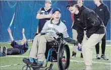  ?? JASON BAIN EXAMINER ?? Holy Cross Secondary School student Mitchell McColl throws a ball, with some help from Jon Hughes, during unified play as part of a Special Olympics bocce qualifying tournament at the Lions Spiplex on March 8.