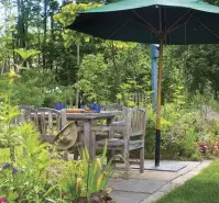  ??  ?? ABOVE A small dining patio of bluestone edged with brick is set into the border garden, with views of the creek and a neighbor’s horse pasture.