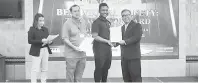  ??  ?? TAHNIAH: Ernest (kanan) menyampaik­an sijil kepada salah seorang peserta sambil disaksikan Dr Julian.