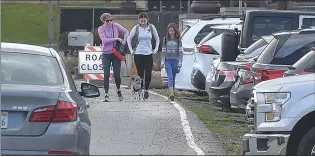  ?? Cory Rubin/The Signal ?? (Above) Stacy Dobbs, left, and her daughters Ellie, 16, and Leilani, 11, and 8-year-old terrier, Kylo, exit a crowded parking lot as they set out on a hike. (Below) Eline Luna, 7, rides the shiny gold hover board she got for Christmas as her father does yard work in Castaic.
