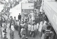  ??  ?? Les habitants faisant la queue devant la banque centrale