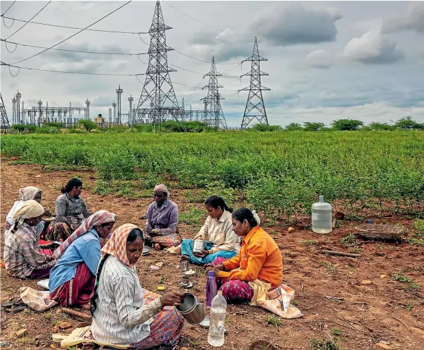  ?? GETTY IMAGES ?? Impoverish­ed workers in India eating beneath electricit­y pylons. Big power projects in India have accelerate­d inequality, with landowners benefiting hugely while the landless poor are pushed further to the margins.