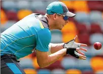  ??  ?? Last-minute preparatio­ns: Australia skipper Steve Smith practises his close catching at The Gabba today
