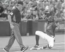  ?? BRIAN MUNOZ/THE REPUBLIC ?? Nick Ahmed slides into third base during Sunday’s 6-1 victory against the Colorado Rockies in Phoenix.