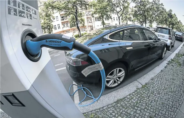  ?? Picture: Getty Images/T Seeliger/Ullstein ?? An electric car from Tesla charges at a station in Berlin. Manufactur­ers expect electric vehicles to become mainstream in SA in the next five to seven years.