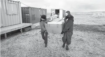  ??  ?? File photo shows members of a forensic team of ICRC carry boxes as they are working to identify the remains of unidentifi­ed Argentine soldiers who died during the Falklands War and are buried at the Darwin cemetery, in the Falkland Islands. — Reuters...