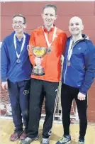  ??  ?? Medals Ross with his trophy flanked by David Eckersley (silver in M55) and Scott Brember (overall silverand M45 winner)