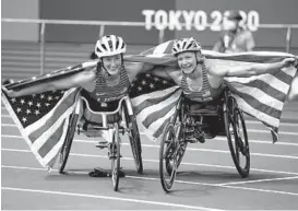  ?? KIICHIRO SATO/AP ?? The United States’ Tatyana McFadden, left, celebrates after finishing in third place in the women’s 5,000-meter T54 race with Susannah Scaroni, right, who won the event during the 2020 Paralympic­s at the National Stadium in Tokyo on Aug. 28.