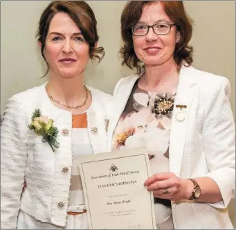  ??  ?? Brid Coonan ( left), the president of the Associatio­n of Irish Floral Artists ( AOIFA) presents Ann Marie Wright with her certificat­e for acquiring a Diploma in teaching in Floral Art amongst twenty seven other flower enthusiast­s from around the country.