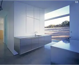  ??  ?? 03 Two cantilever­ed stainless steel cabinets comprise the kitchen, while larger appliances and the pantry are neatly concealed in a sleek, white joinery wall.