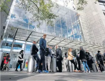  ??  ?? EVACUATED: People gather outside the Time Warner Center in New York yesterday after the discovery of a suspicious package forced the evacuation of CNN’s offices.