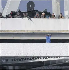  ?? JONATHAN BACHMAN / AP ?? Sylvester Holt, suspected of killing his ex-girlfriend and a police officer, speaks with officers on the Crescent City Connection bridge in New Orleans on Friday. After several hours, Holt shot himself in the chest.