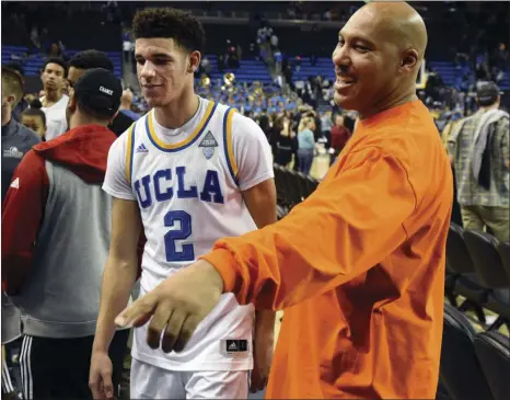  ?? AP PHOTO ?? In this Nov. 20 file photo, UCLA's Lonzo Ball (left) walks by his father LaVar Ball to greet family members after UCLA defeated Long Beach State in an NCAA college basketball game in Los Angeles.