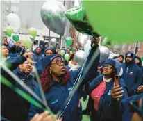  ?? VINCENT ALBAN/CHICAGO TRIBUNE ?? Lisa Tillis, center, a post office worker, looks up at a balloon release Saturday in memory of Branch 11 of the National Associatio­n of Letter Carriers union member Mechellea Williams at the Fort Dearborn-Chestnut Station post office in Chicago.