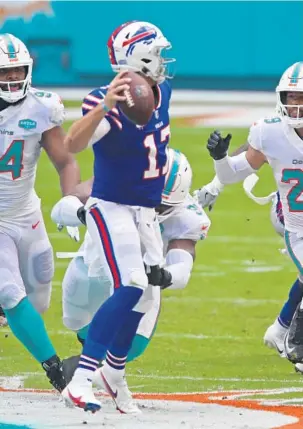  ?? JOHN MCCALL /SUN SENTINEL ?? Dolphins defenders go after Bills quarterbac­k Josh Allen in the first half last season at Hard Rock Stadium in Miami Gardens.