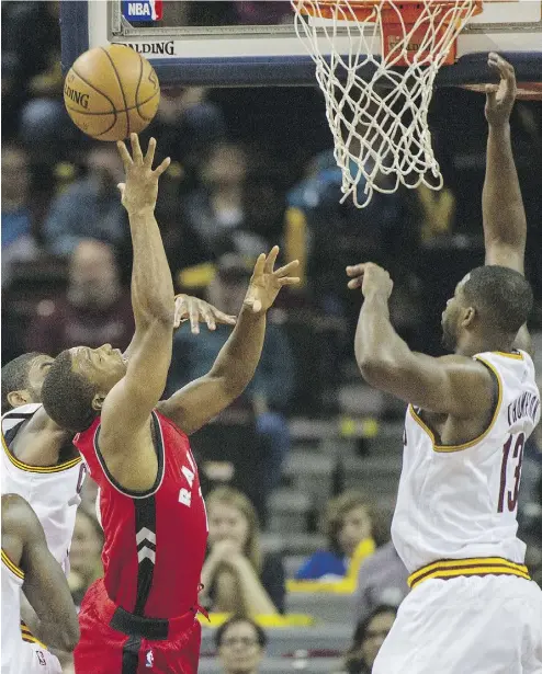  ?? PHIL LONG / THE ASSOCIATED PRESS ?? Toronto Raptors’ Kyle Lowry, in red, lunges for a rebound in a preseason NBA game Thursday in Cleveland, which the Raps won 119-94. There’s little heat between Toronto and Cleveland despite a looming baseball playoff series.