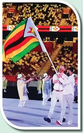  ??  ?? Swimmer Donata Katai (right) and rower Peter Purcell-Gilpin lead the Zimbabwe team during the opening ceremony. The ceremony, which marks the official kickoff of the Olympics, was held in Tokyo yesterday under the cloud of COVID-19, where spectators were barred while the number of athletes was reduced.