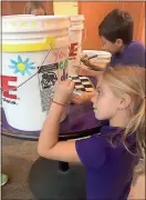  ?? / Darlington ?? Darlington Lower School third-graders Ivey Dunn and Victor Chin decorate a relief kit.